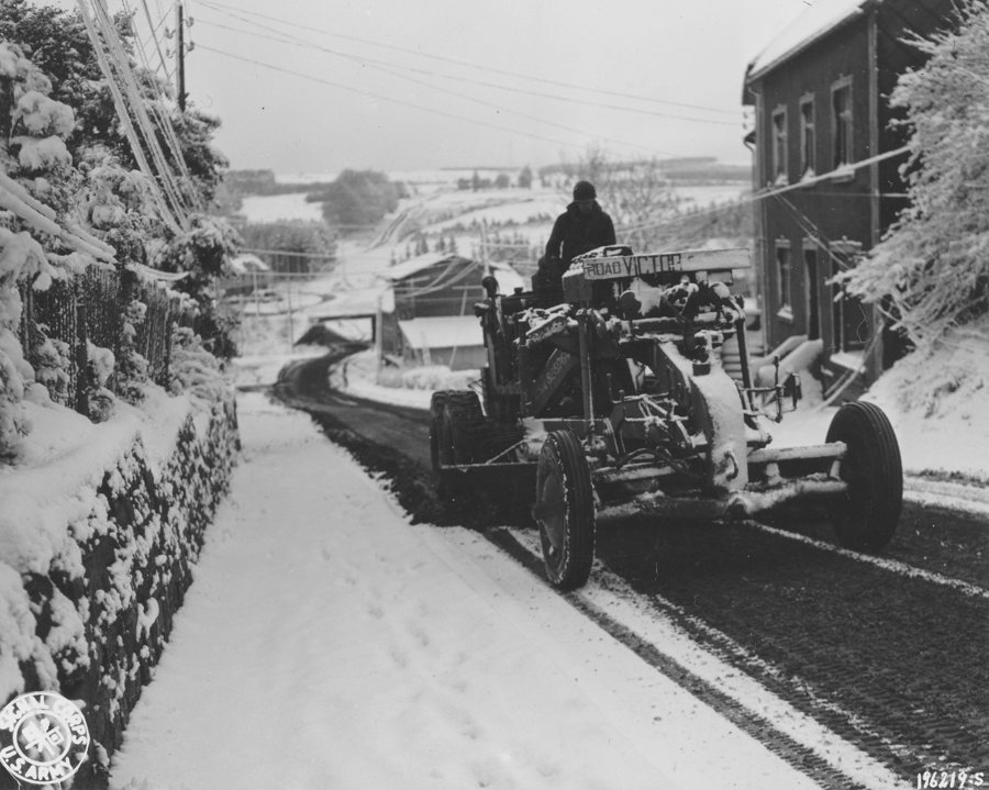 File:SC 196219-S - A member of an Engineer unit uses a grader to clear the first snowfall off a road near Butgenbach, Belgium. 1st Army area, 9 November, 1944. (51981407966).jpg