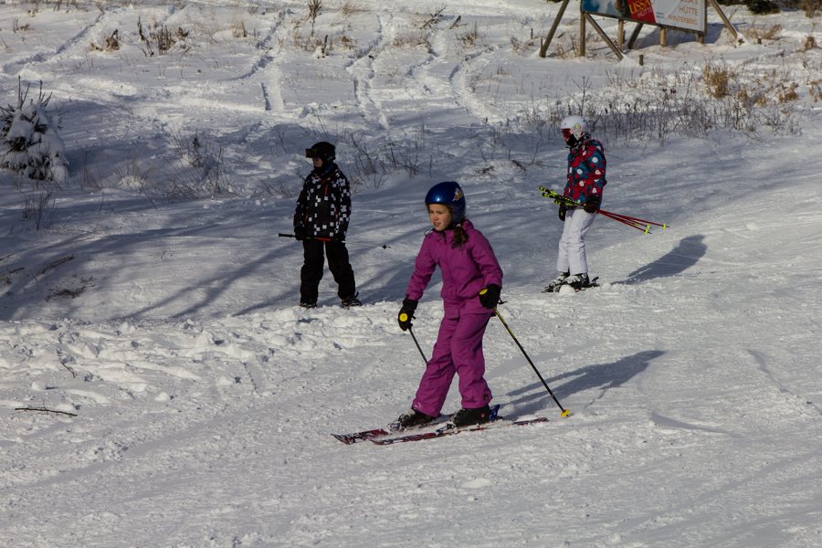 Niños esquiando por una ladera nevada